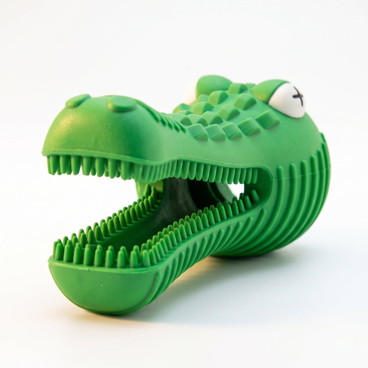 A green alligator-shaped silicone pet toy with an open mouth, textured scales, and a small white eye detail, shown on a plain white background.