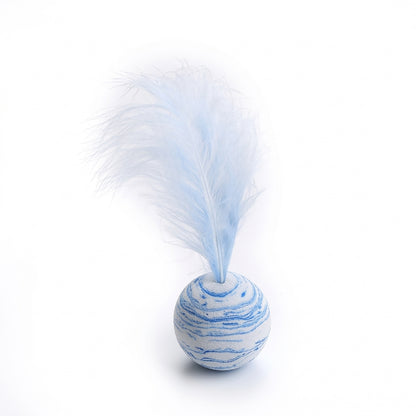 A small decorative toy or fidget ball with a blue and white marbled pattern, topped with a fluffy pale blue feather, photographed on a clean white background.