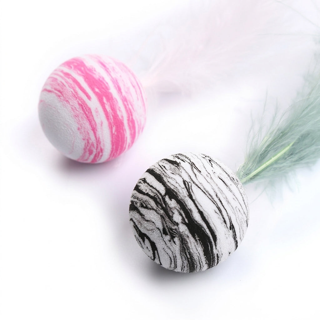 Two feather wands on a white background, one with a pink and white marbled ball and white feather, and the other with a black and white marbled ball and mint green feather.